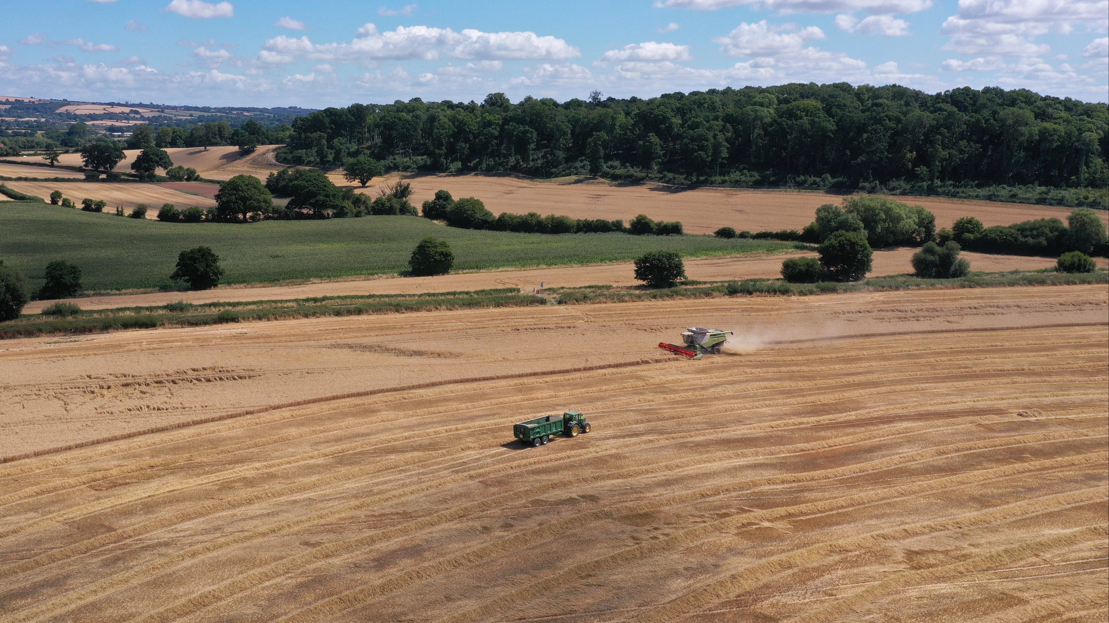 Aerial view of a tractor working in a field with a clear blue sky.